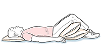 Hombre acostado boca arriba con almohadas debajo de la cabeza y las rodillas.