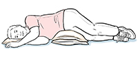Hombre acostado de lado con almohadas debajo de la cabeza y la cadera.